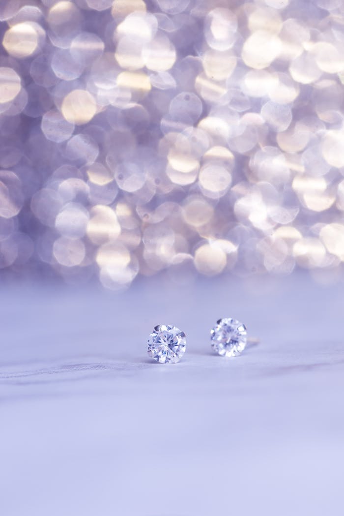 Close-up shot of sparkling diamond earrings against a beautiful bokeh background, showcasing luxury.